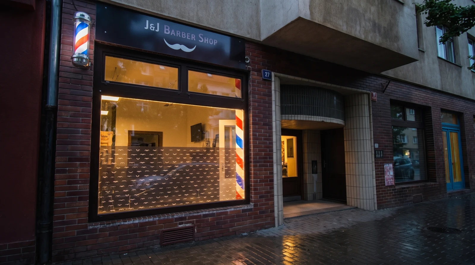 Výloha barbershopu J&J ve Vršovicích za soumraku