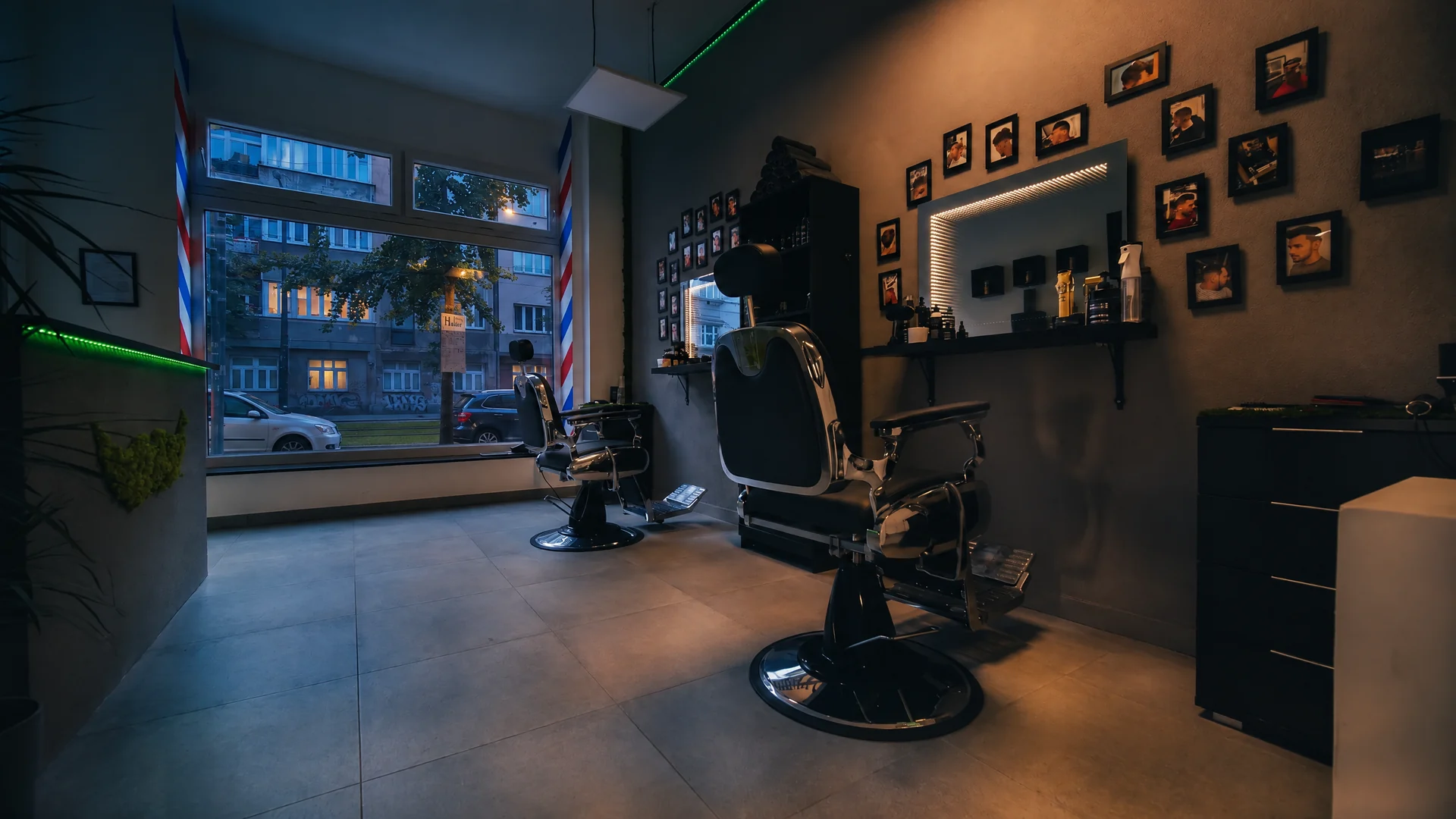 Interiér J&J Barber Shop ve Vršovicích za modré hodinky, za výlohou Vršovická ulice s tramvajovou tratí